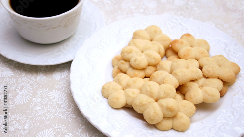 Plate of homemade sprtz cookies and a cup of black coffee.