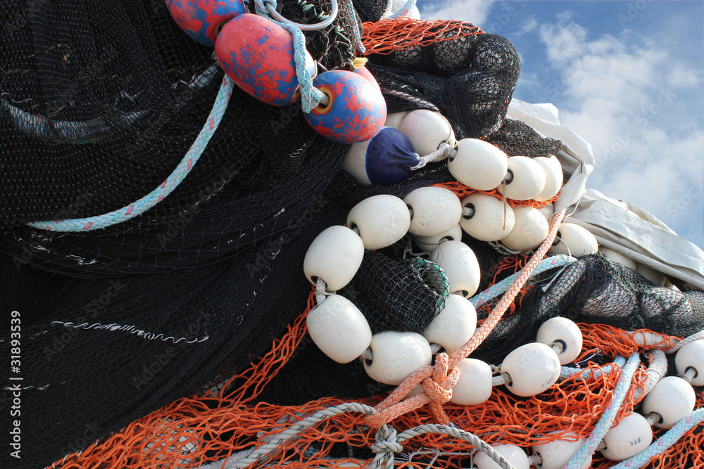 A pile of commercial fishing nets against a blue sky