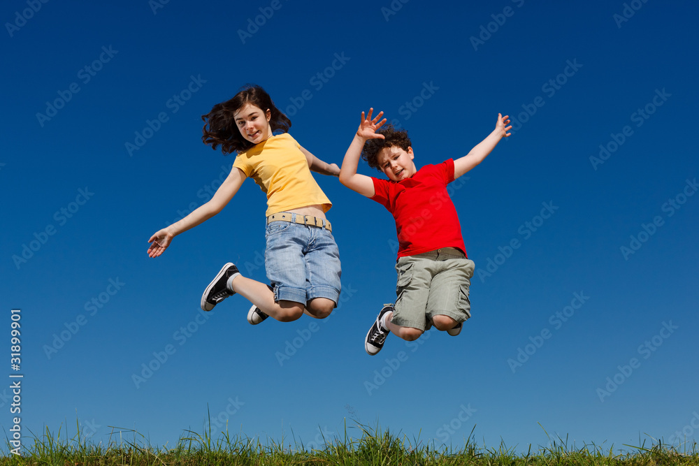 Girl and boy jumping, running against blue sky Girl and boy jumping, running against blue sky
