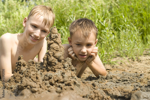 Two children build a sand castle