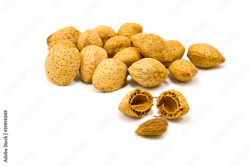 Obraz premium Almond pile macro with cracked one showing seed on white