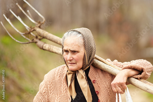 Foto Senior farmer woman with a fork
