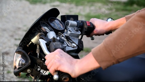 Close-up hands revving a motorcycle