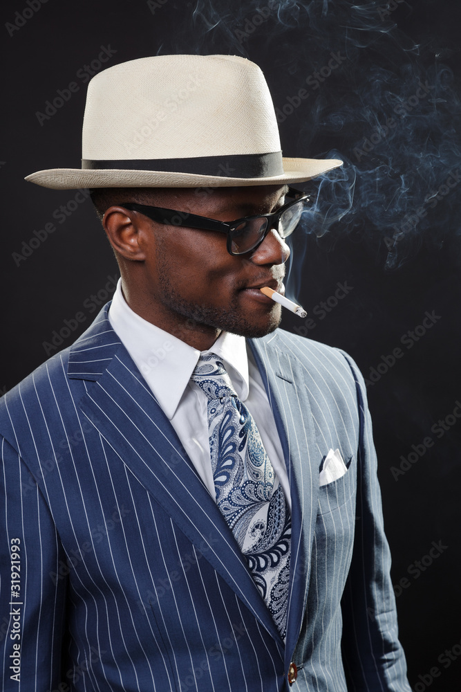 Black man with blue striped suit and white hat smoking cigarette Black man with blue striped suit and white hat smoking cigarette