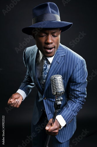 Photography Black man with blue striped suit and blue hat singing.