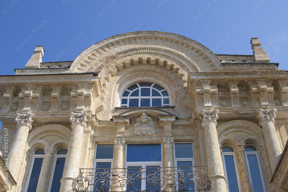 architectural building with columns, railings and arched windows