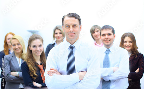 Business man at the office with a group behind him