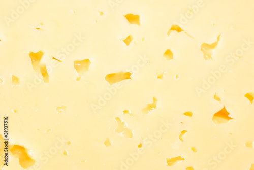 Background of fresh yellow cheese with holes