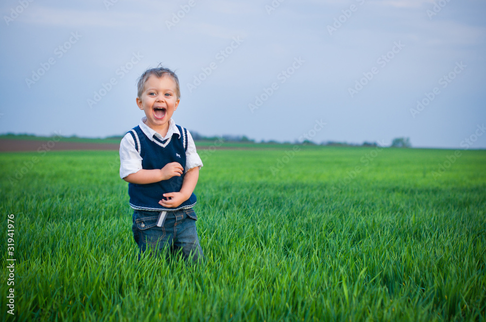 A beautiful little boy staing in the grass A beautiful little boy staing in the grass