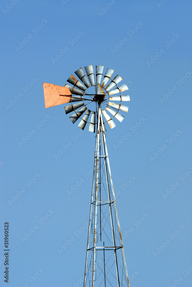 Green energy windmill used to pump water. Vertical copyspace