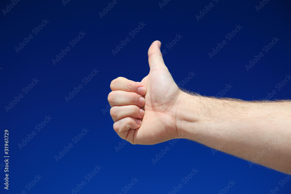 Person zeigt Daumen hoch vor blauem Himmel Person zeigt Daumen hoch vor blauem Himmel