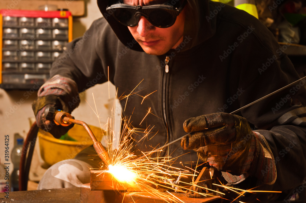 worker welding with hot flame and sparks - obrazy, fototapety, plakaty 