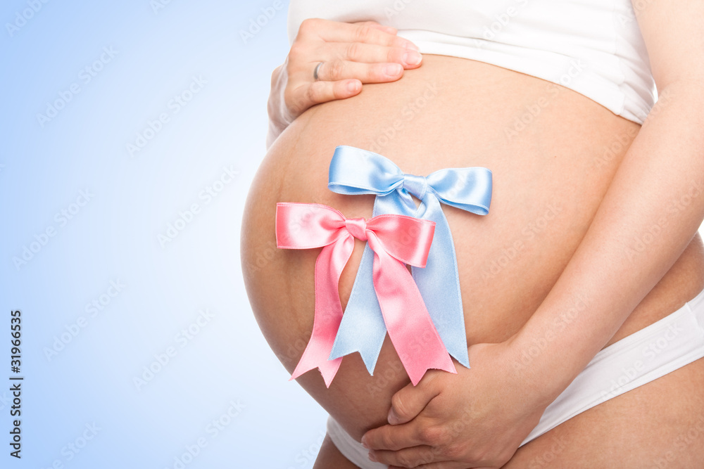 Beautiful young pregnant woman with ribbon. Isolated
