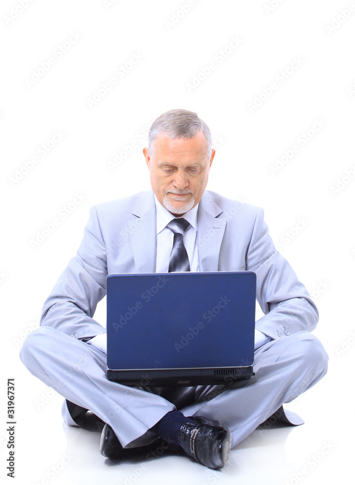Executive sitting on the floor cross-legged with laptop Executive sitting on the floor cross-legged with laptop