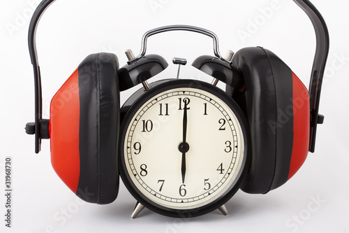 Alarm clock with ear defenders on. Conceptual idea for no noise.
