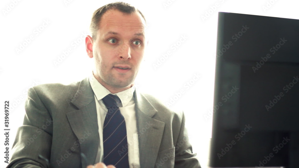 Young businessman working on computer and smiling to camera Young businessman working on computer and smiling to camera