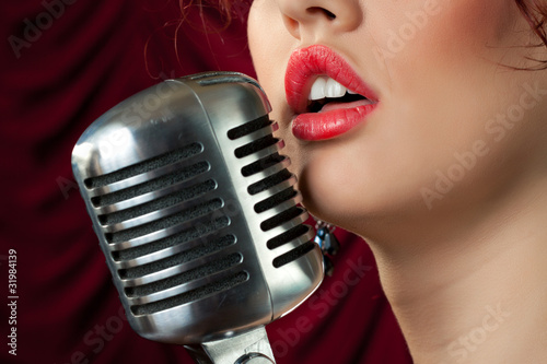 woman with red lips singing in vintage microphone