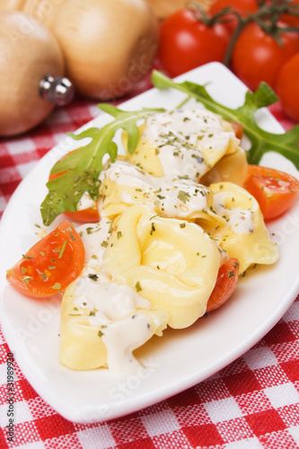 Tortellini pasta with cheese sauce and tomato