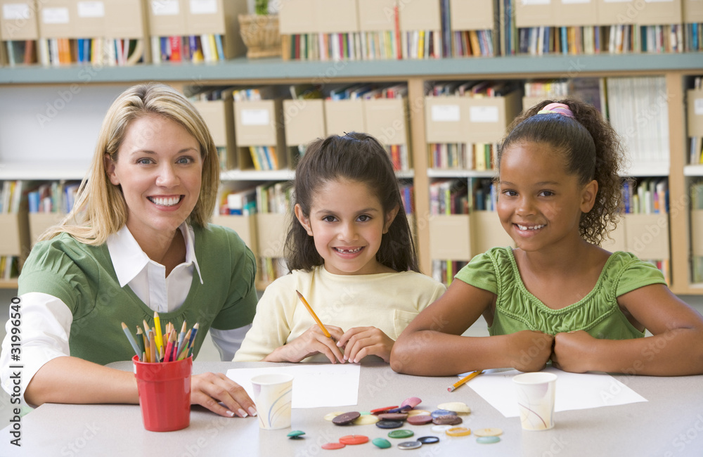 Fototapeta premium Kindergarten teacher sitting with students in art class
