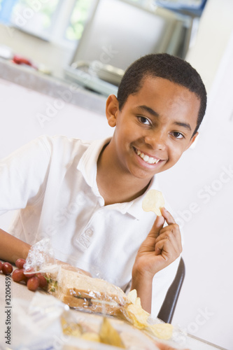 Schoolboy enjoying his lunch in a school cafeteria