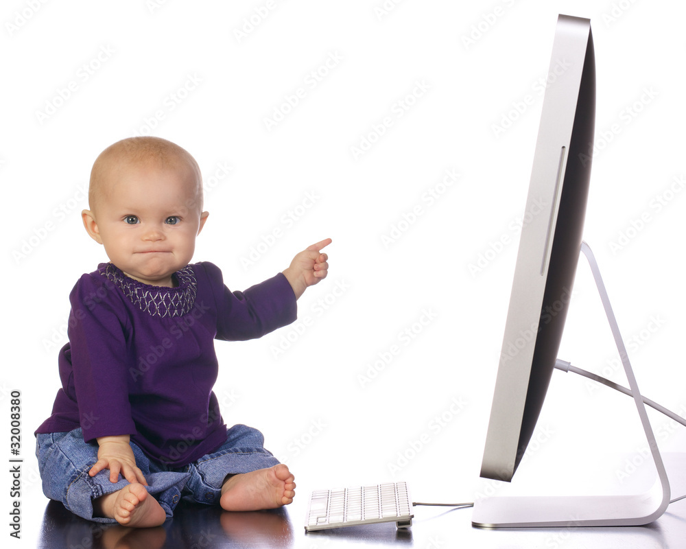 Infant girl typing on a desktop computer Infant girl typing on a desktop computer