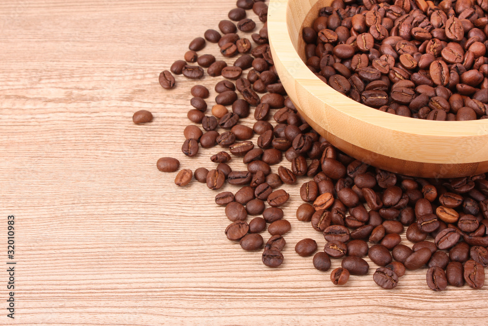 Plate with coffee beans on wooden table Plate with coffee beans on wooden table