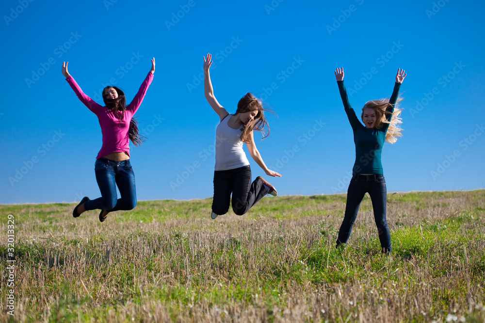 three young beautiful woman jumping into the field against the s three young beautiful woman jumping into the field against the s