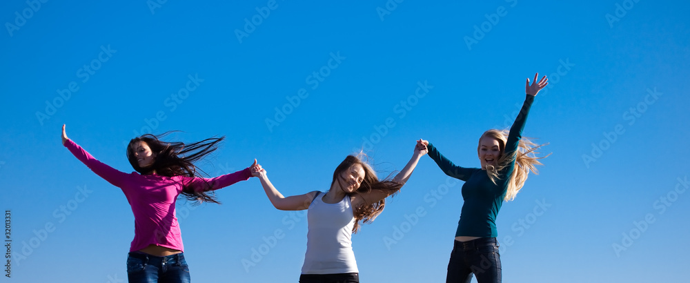 three young beautiful woman jumping into the field against the s three young beautiful woman jumping into the field against the s