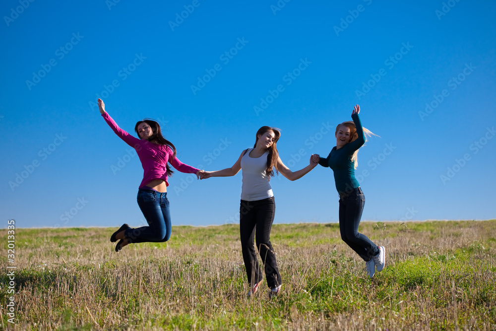 three young beautiful woman jumping into the field against the s three young beautiful woman jumping into the field against the s