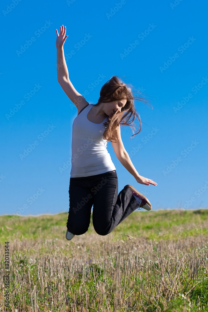 young beautiful woman jumping into the field against the sky young beautiful woman jumping into the field against the sky