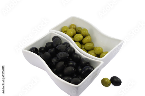 black and green olives in white bowls isolated on white