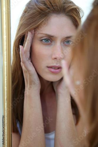 Beautiful woman looking in a mirror