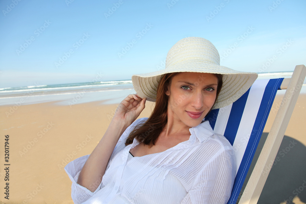 Beautiful woman resting in deckchair at the beach