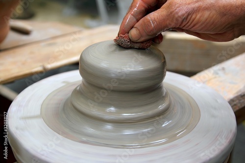 man potter hands working on pottery clay wheel
