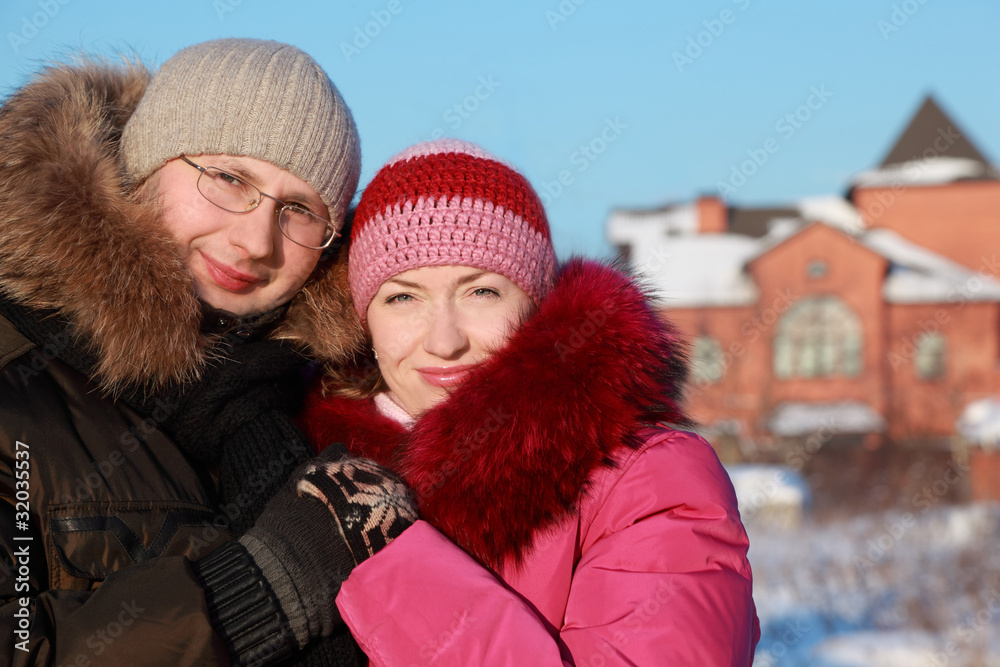 woman in pink jacket and man in glasses at winter
