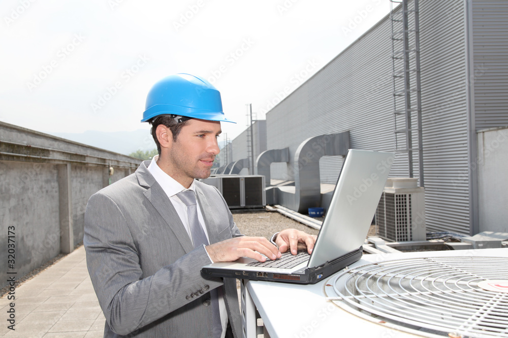 Businessman checking industrial installation Businessman checking industrial installation