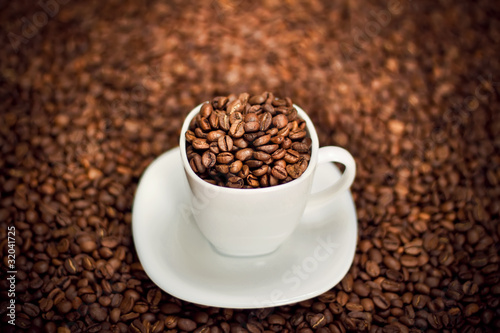 White cup filled with coffee beans