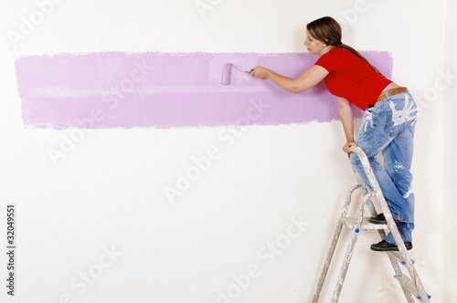 Junge Frau streicht eine Wand