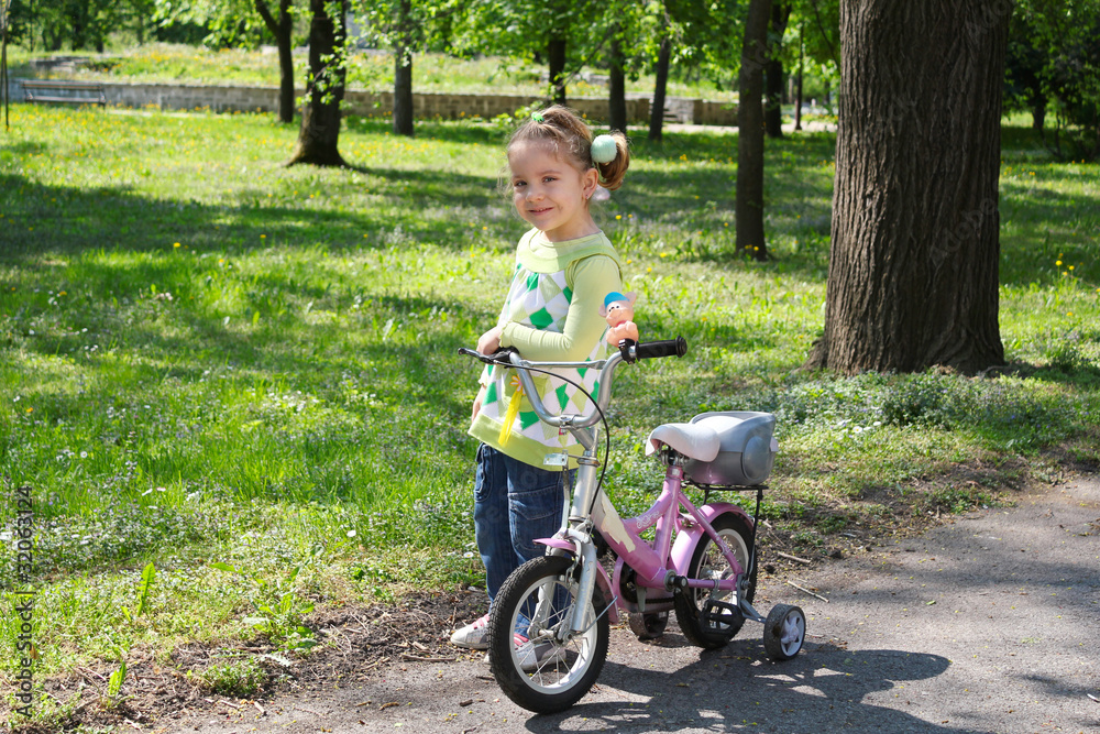 little girl with bicycle posing in park little girl with bicycle posing in park