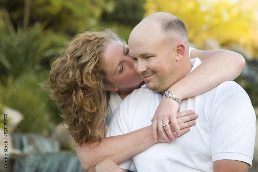 Attractive Couple Kiss on the Cheek in the Park. Attractive Couple Kiss on the Cheek in the Park.