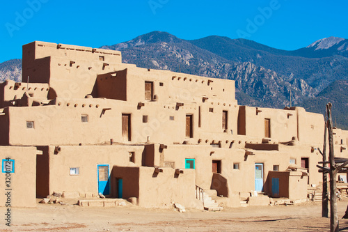 Ancient Taos Pueblo with mountains on background, New Mexico photo