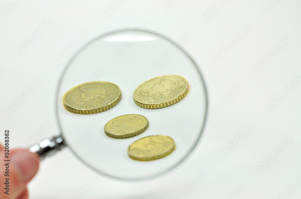 Fototapeta premium Geldmünzen mit Lupe