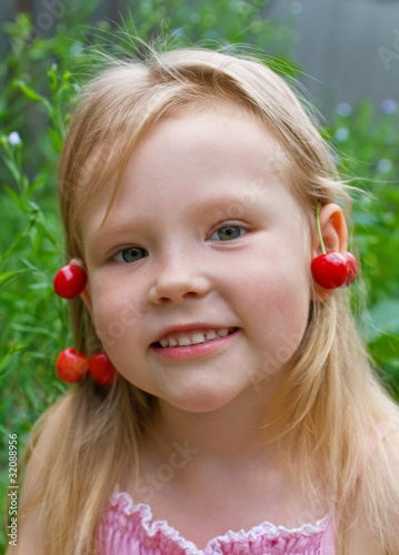Beautiful little girl with earrings made of berries
