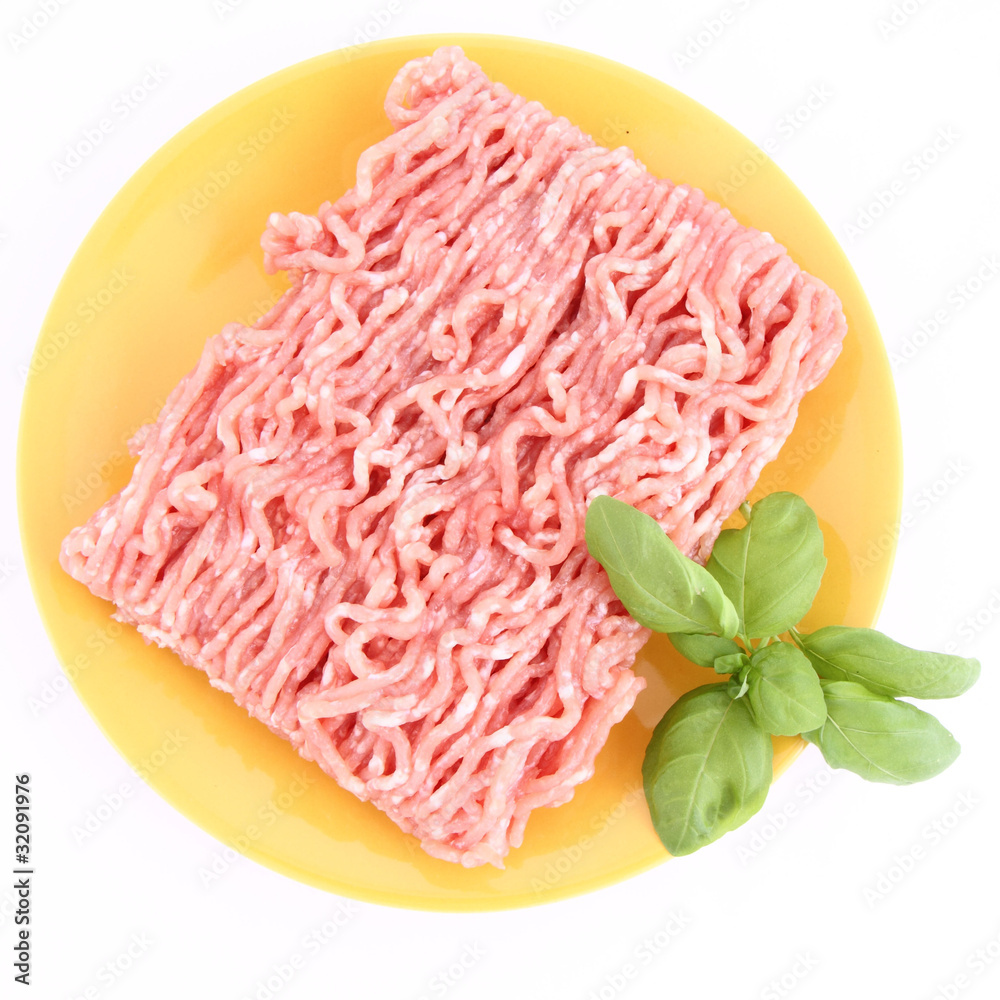Raw minced meat on a plate decorated with basil