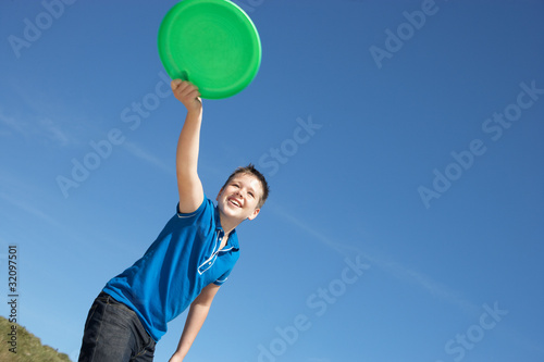 Boy playing frisbee on beach © micromonkey