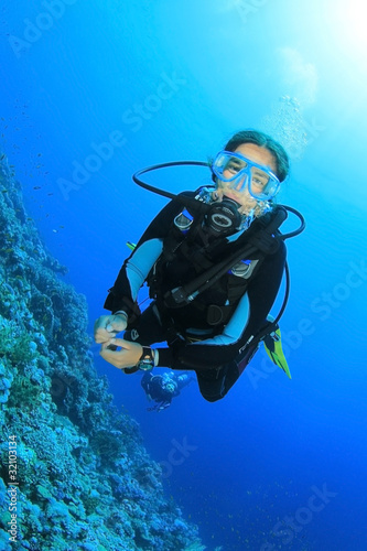 Young Woman Scuba Diving in clear blue water