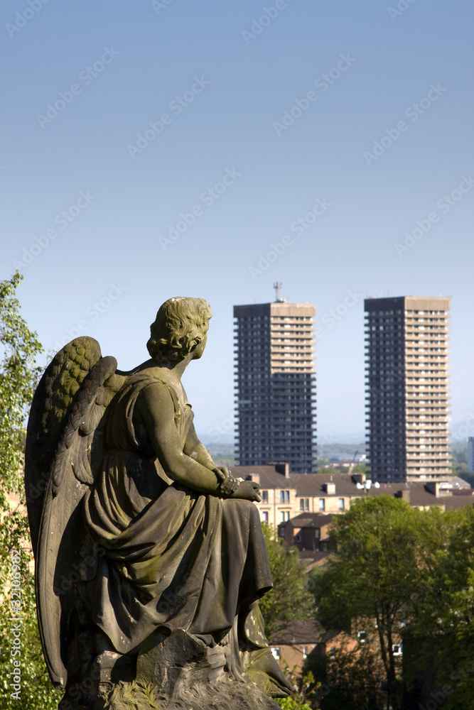 Urban angel contemplating high-rise tower blocks
