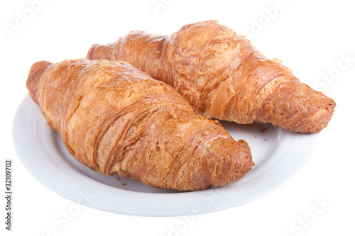 Two delicious croissants on a plate, isolated on white