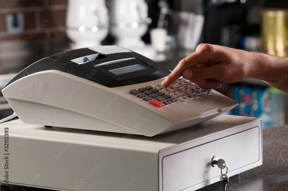 Closeup of a cashier's hand ringing cash register. - obrazy, fototapety, plakaty 