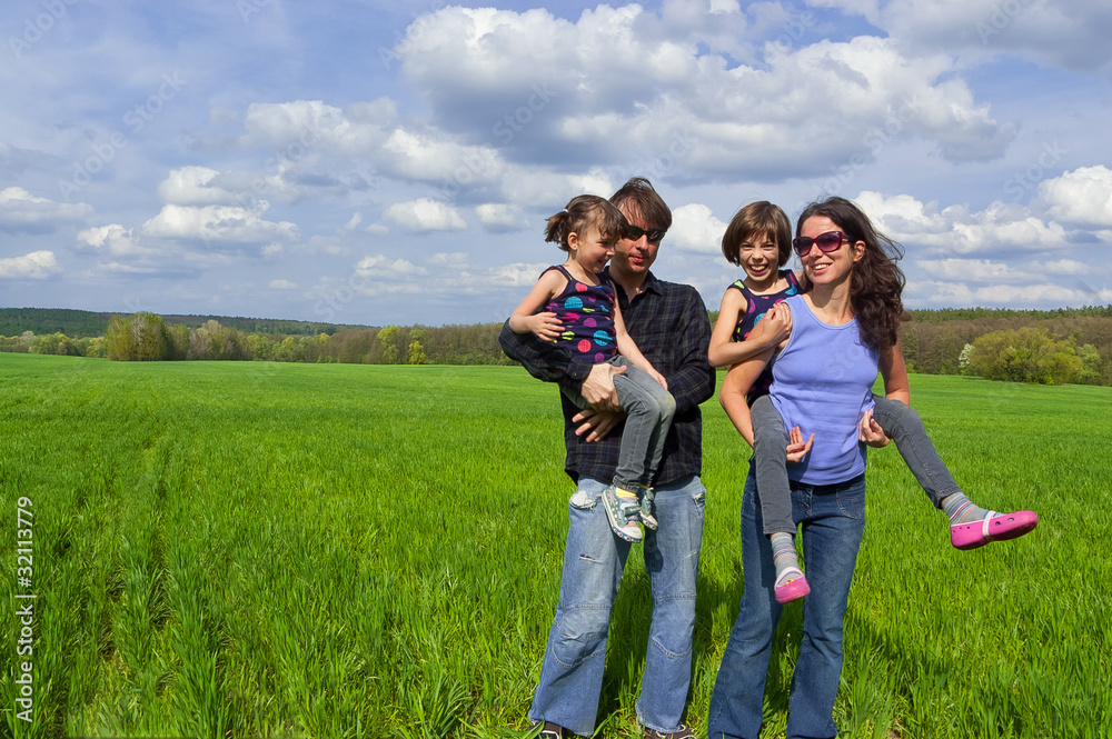 Happy family outdoors. Parents giving their kids piggyback ride Happy family outdoors. Parents giving their kids piggyback ride